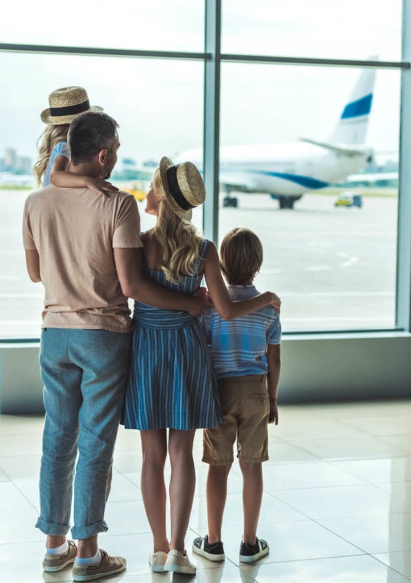 family of four looking at planes out the window at the airport