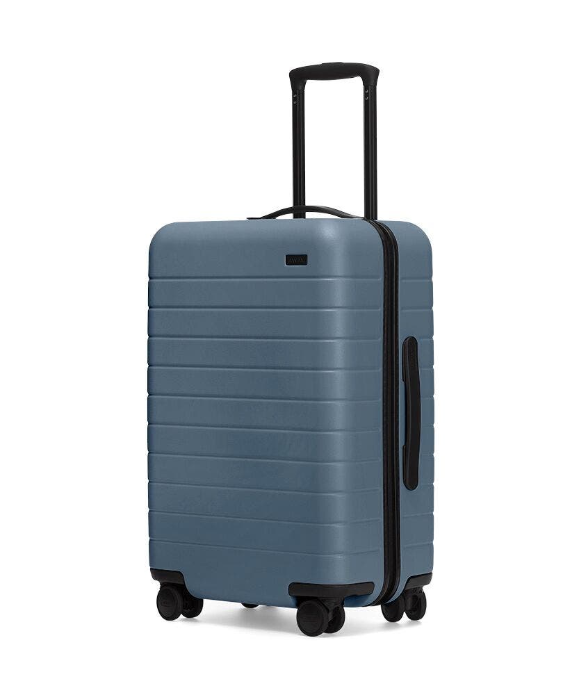 A blue carry-on suitcase from Away Luggage.