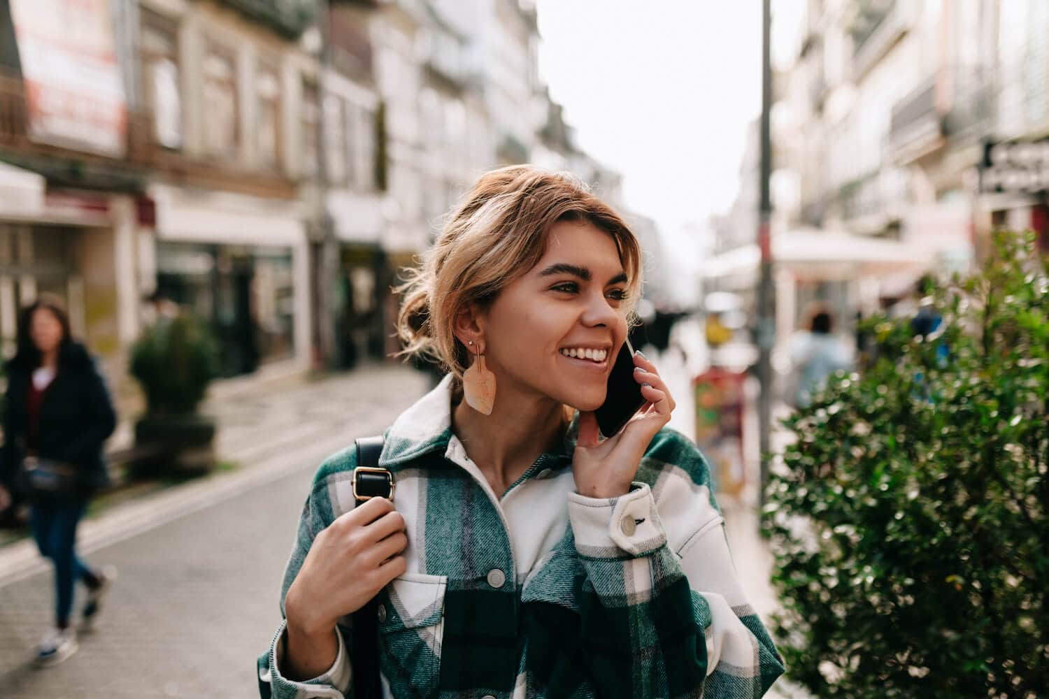 Teen girl talking on cell phone on city street